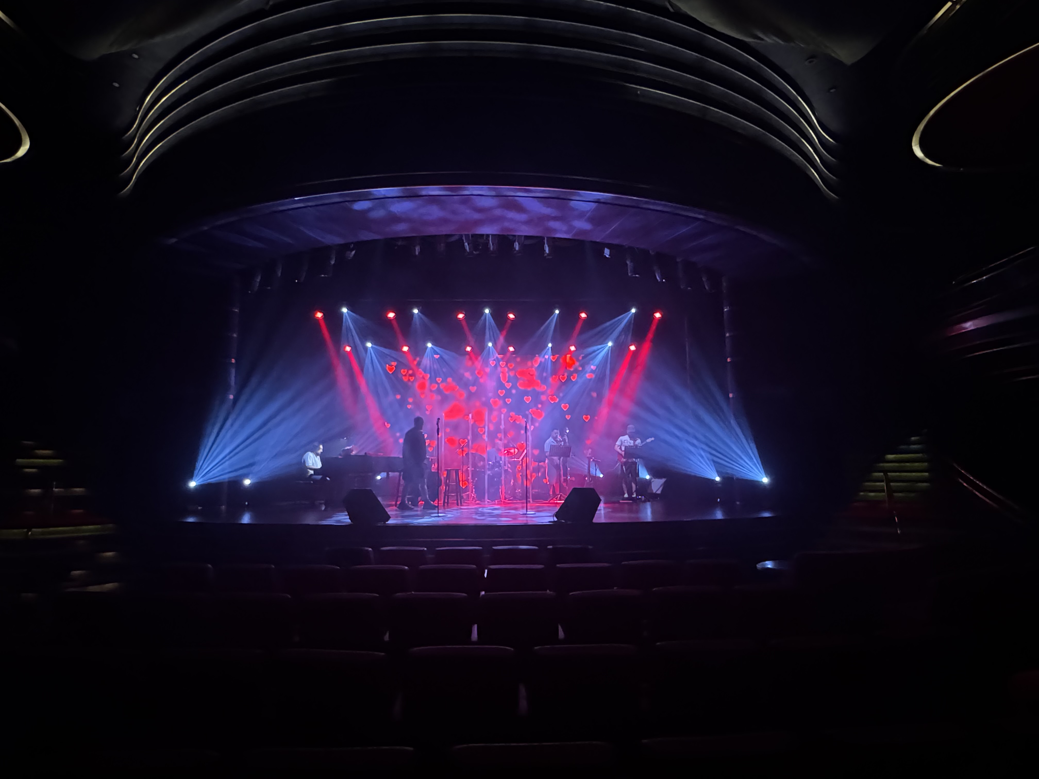 Live band performing on stage with dramatic red and blue lighting