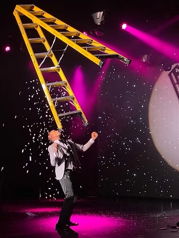 Johnny Balance performing his signature ladder balancing act on stage